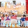 Donald, Minnie, Mickey y sus amigos con atuendos náuticos bailan en la cubierta del barco.